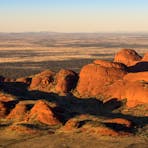 Small and large red rocks on a flat plain