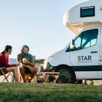 Couple enjoying a picnic by Star RV motorhome