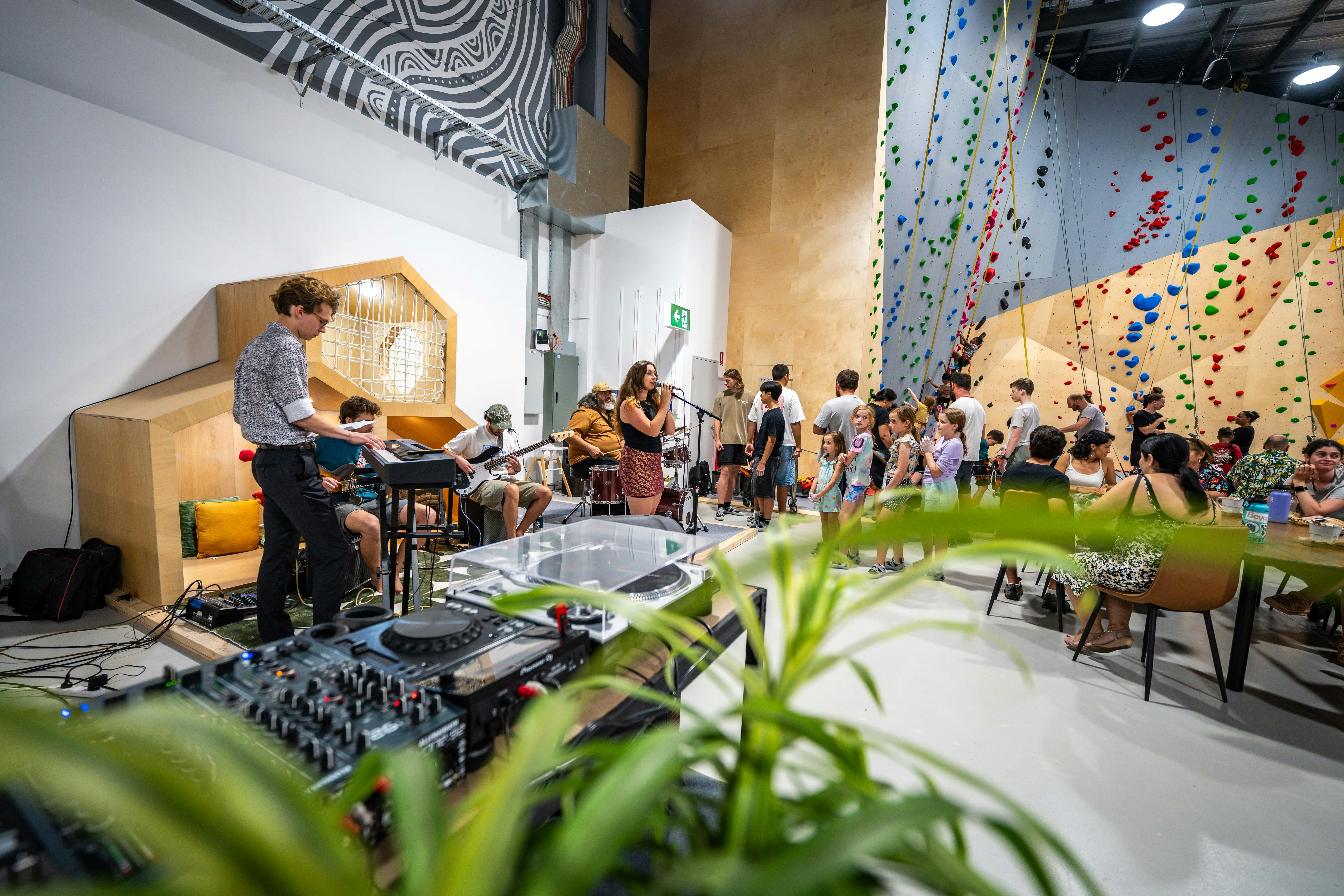 band playing in the rock climbing gym, people climbing in the background