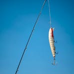 Fishing rod with lure and blue sky