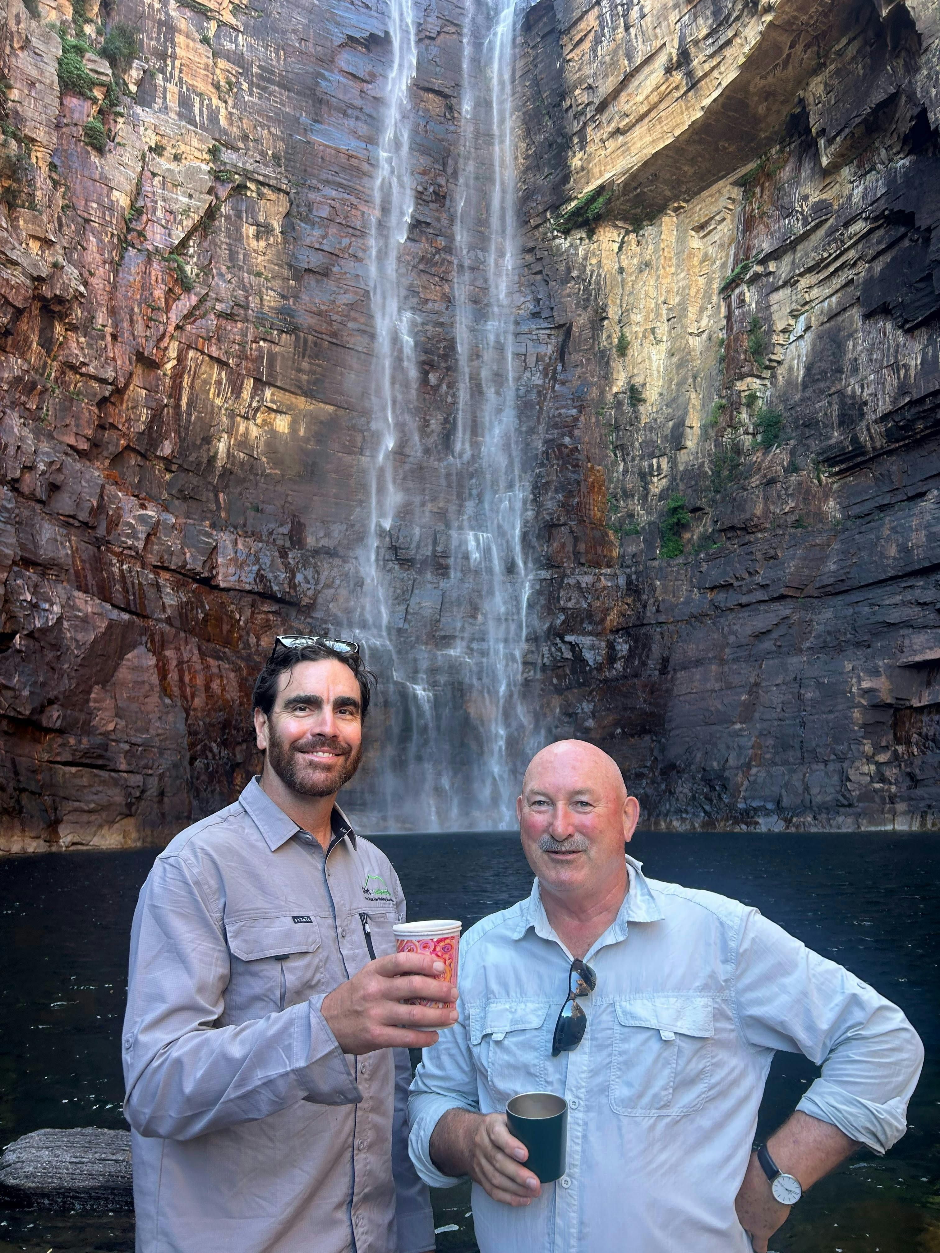 Guests enjoying a waterfall in Kakadu National Park during a guided walking tour in the Northern Ter