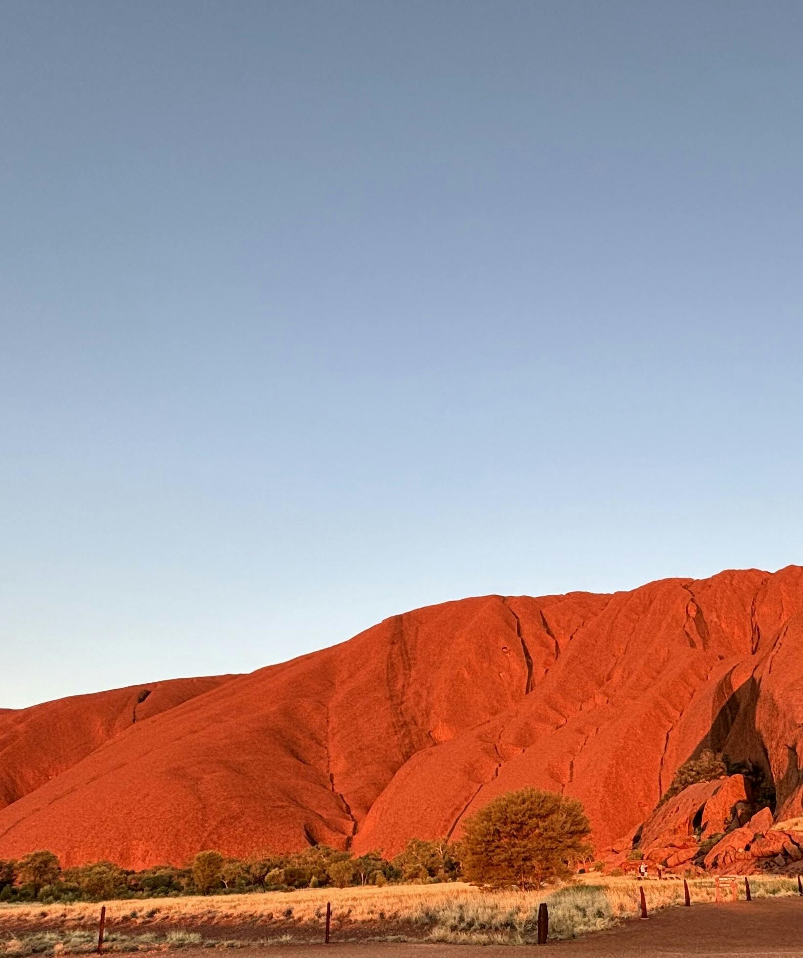A photo from a sunset tour shows Uluru glowing a brilliant red, so close you could almost touch it.