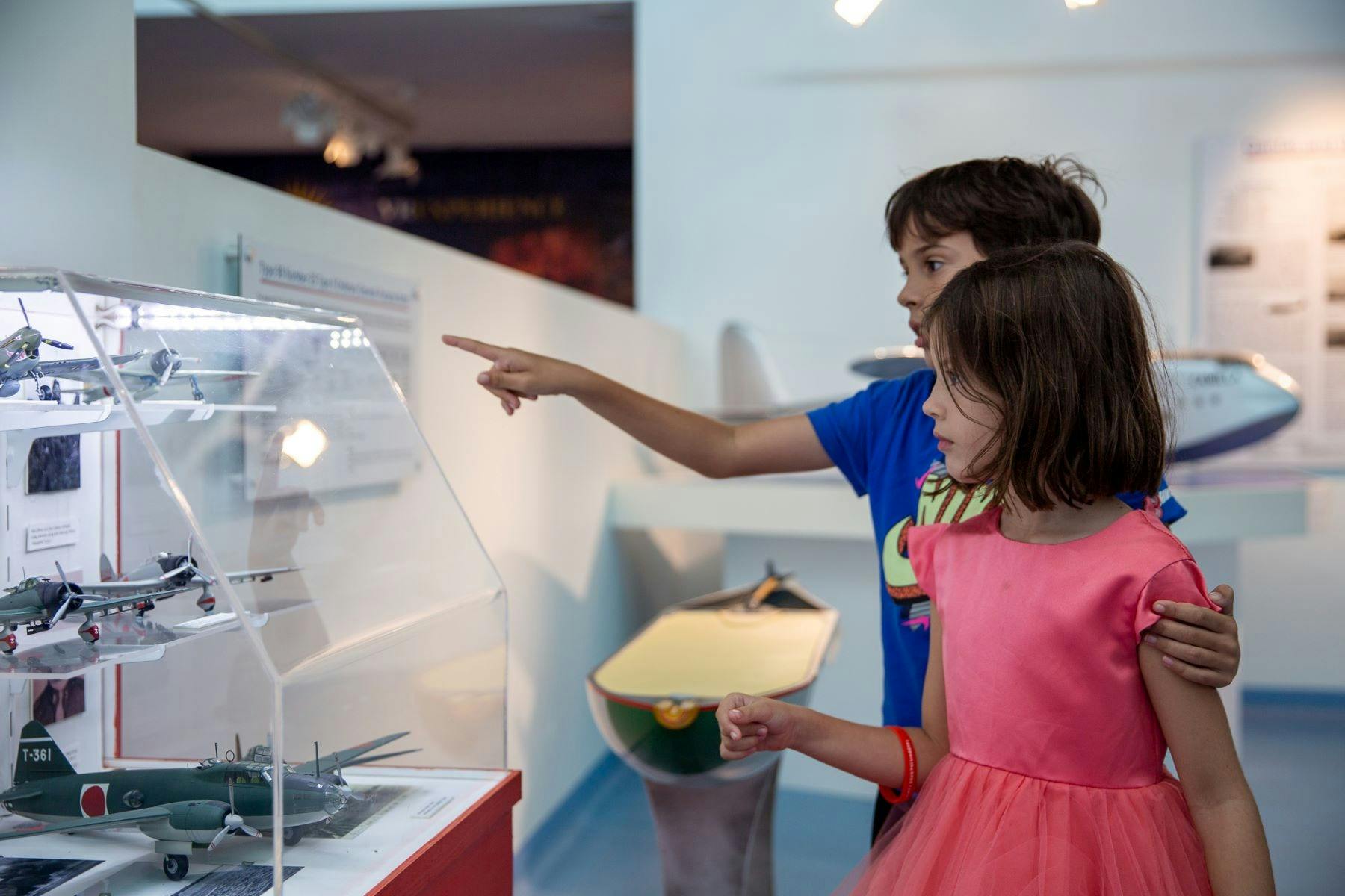 2 children looking model airplanes WWII