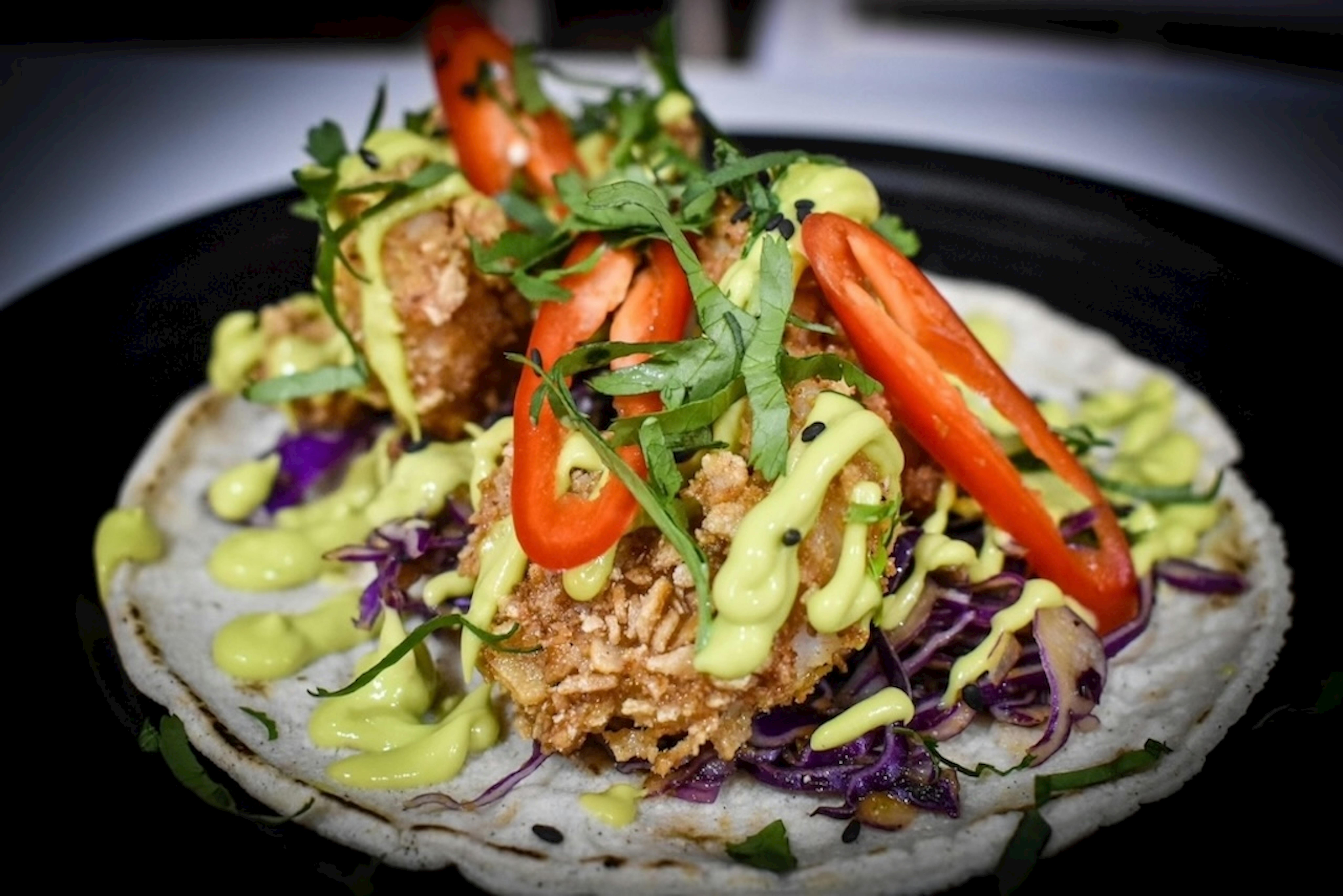 Crispy prawn taco with avocado creme