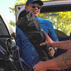 Two campers unpacking camping equipment from the back of a car