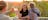A person takes a photo of a woman standing next to an Aboriginal man with a didjeridoo