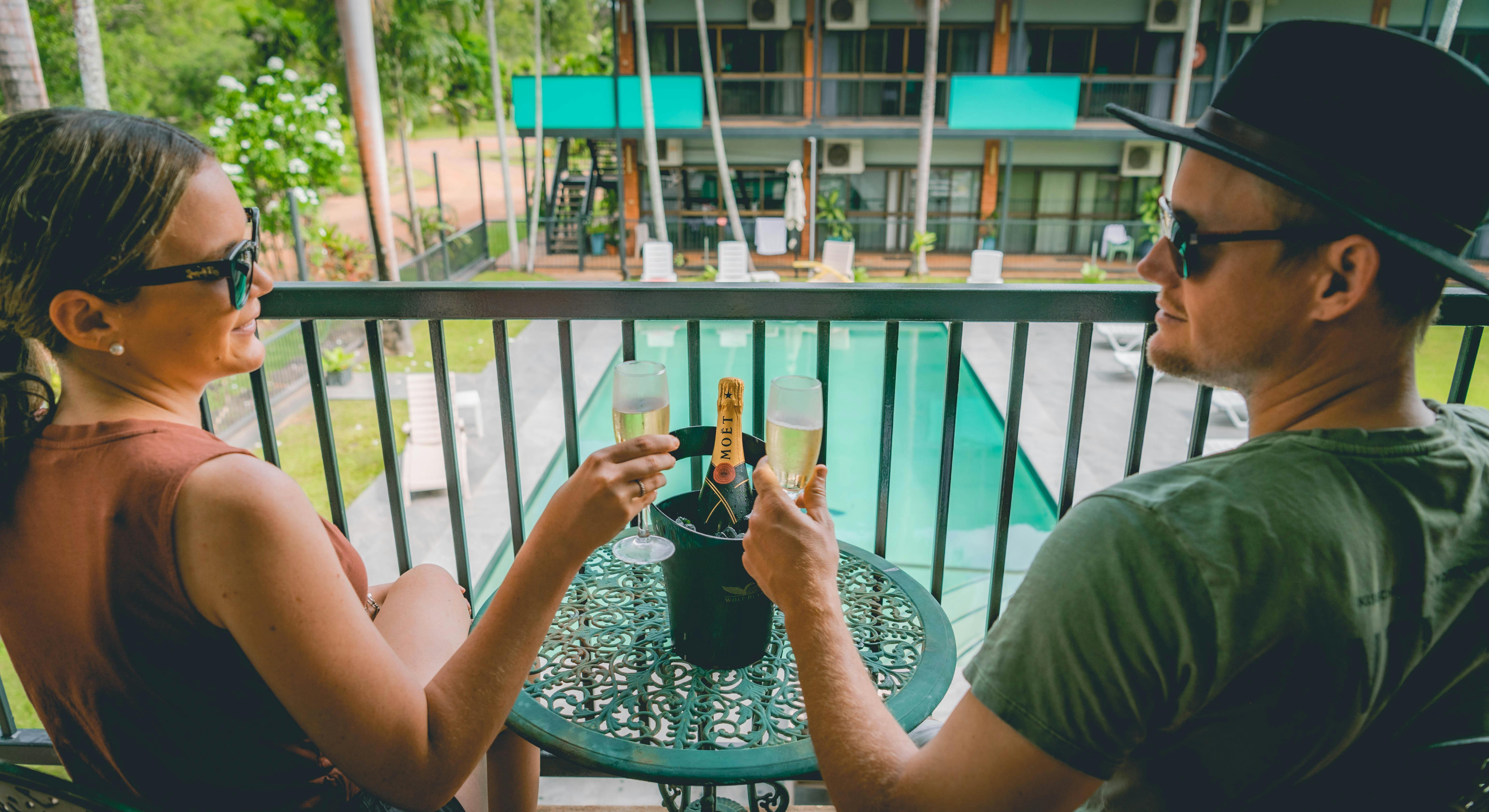 Couple enjoying a glass of Champagne on the balcony at Litchfield Outback Resort