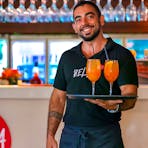 Staff member carrying tropical cocktails.