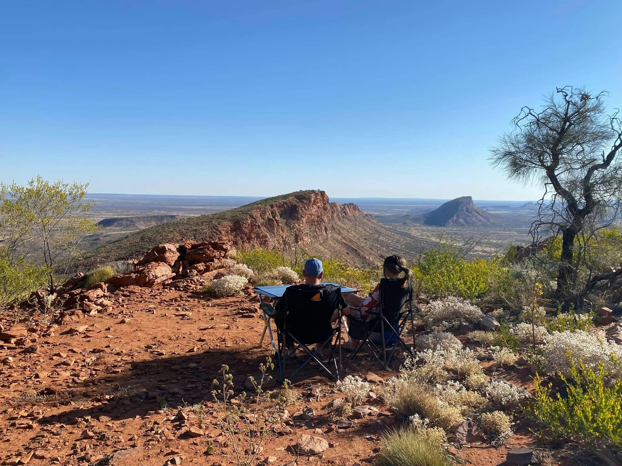 Couple enjoying the views and serenity after landing on top of the East MacDonnell Ranges