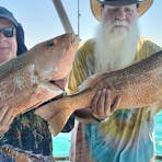 A man holding a fish on a Darwin Red Devil Charter.