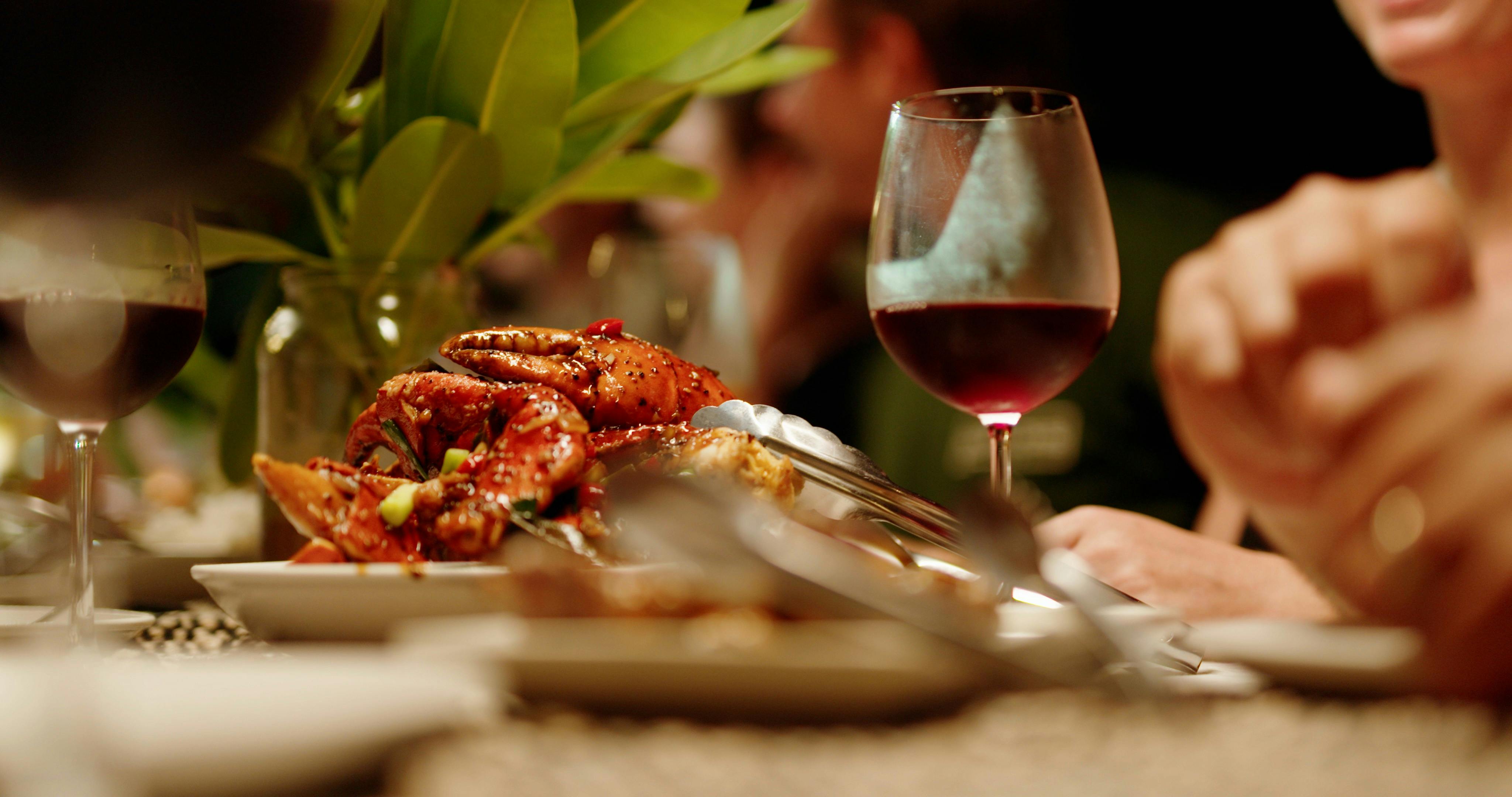 Chilli mud crab on table for a group beach dinner with a glass of wine