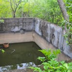 Concrete cistern. Adjacent are water tank slabs and remnants of a tank stand.