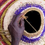 Artist Mary Pan from Amata, SA, working on her Tjanpi basket.