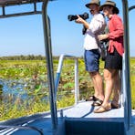Two people looking at the wetlands on board river cruise boat