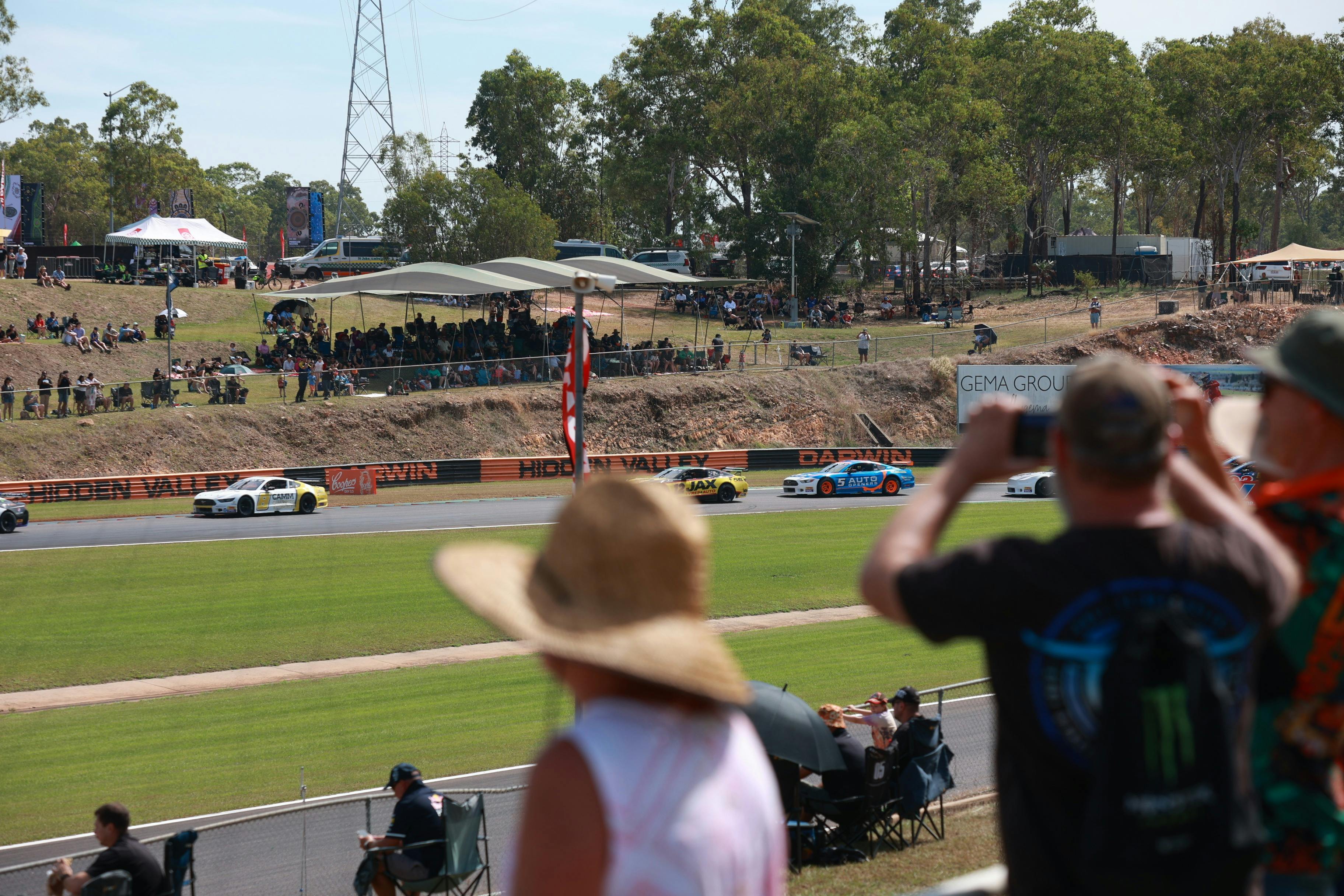 Spectators in foreground watching cars on track