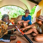 Couple with artist painting a didgeridoo