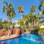 Palm-lined swimming pool with waterfall