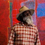 2024 Telstra Art Award Winner Noli Rictor standing in front of his painting Kamanthi 2023