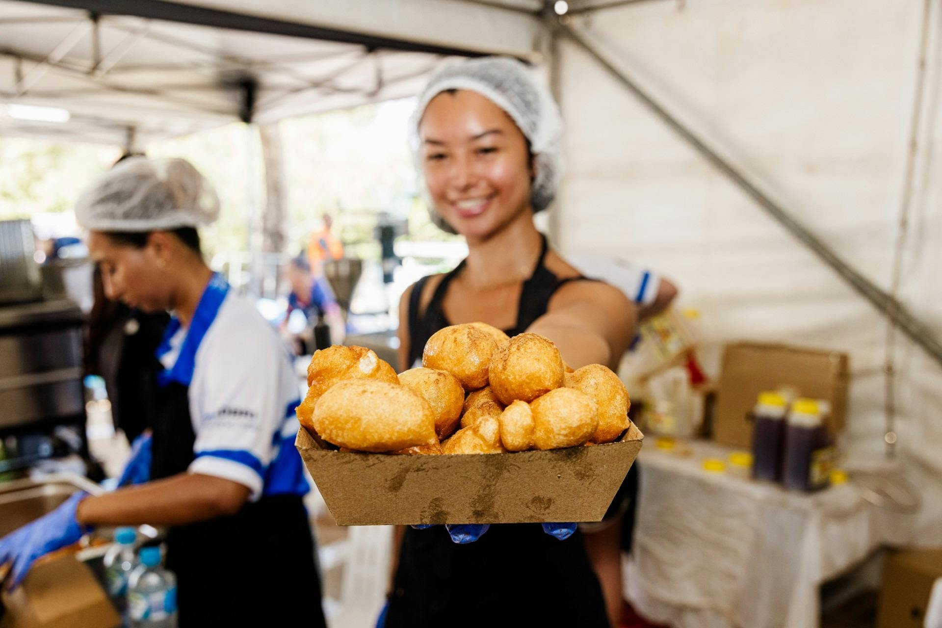 Young woman serving honey puffs