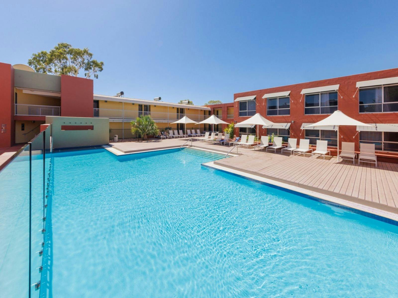 Swimming pool with umbrellas and pool chairs on a deck