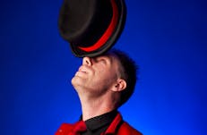Comedian balancing a hat on his nose