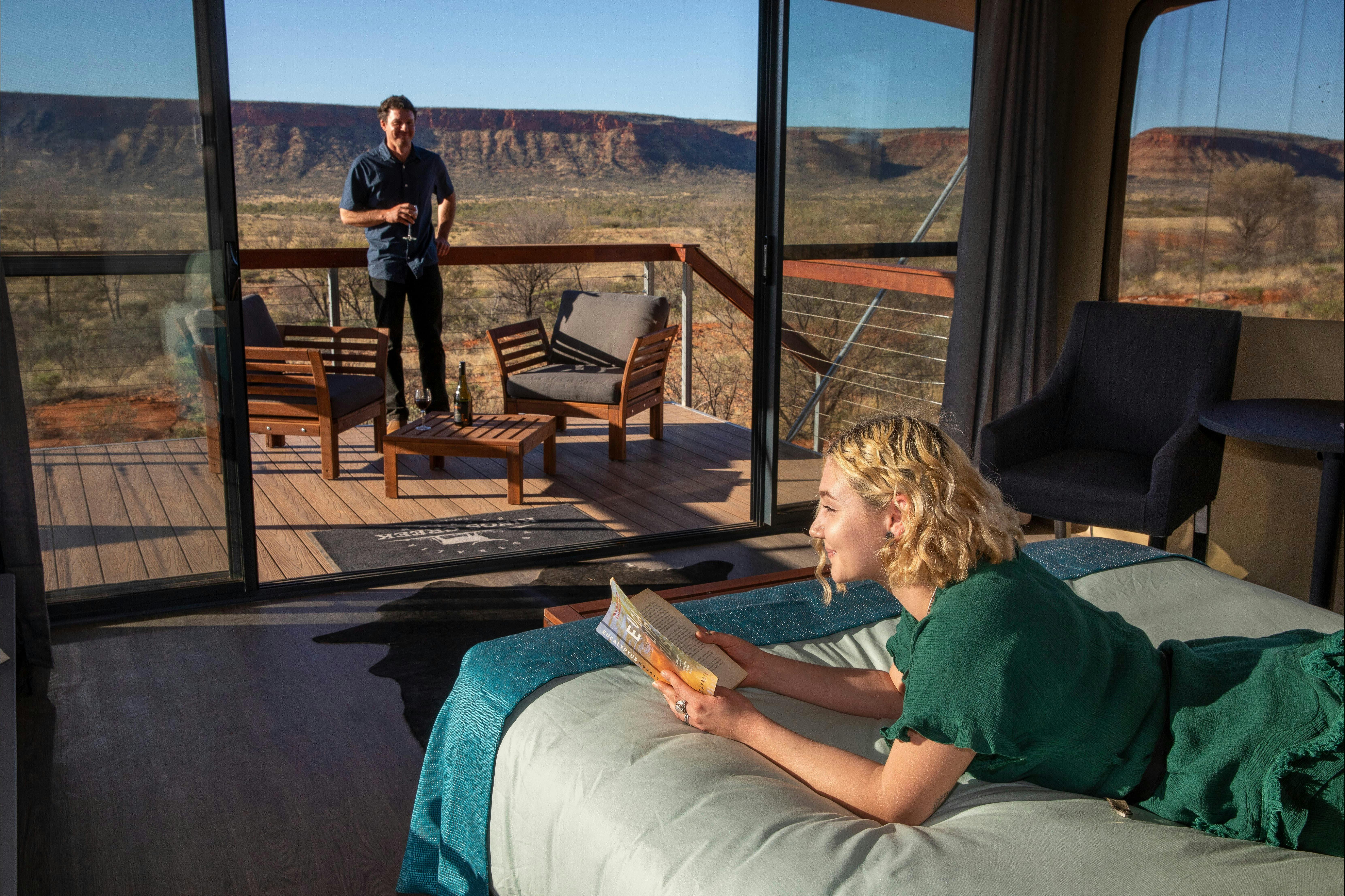 A man and a woman relax in a luxury tent at Drovers Dream, King Creek Station.