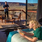 A man and a woman relax in a luxury tent at Drovers Dream, King Creek Station.