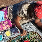 Artist, Pauline Ryan Nanaku, painting a children's story in the warm winter sun.