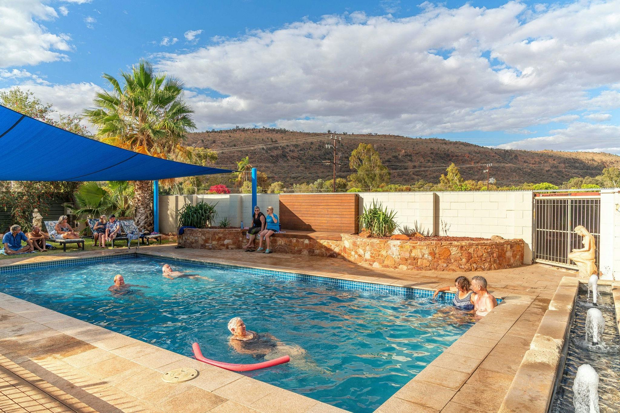 Large swimming pool with grass area and sun lounges. Shade sail also.