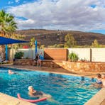 Large swimming pool with grass area and sun lounges. Shade sail also.