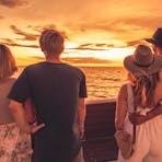 4 friends standing looking out at the sunset