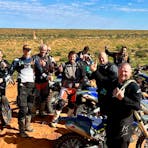 Riders grouped together enjoying the view from atop a sand dune on the QAA line