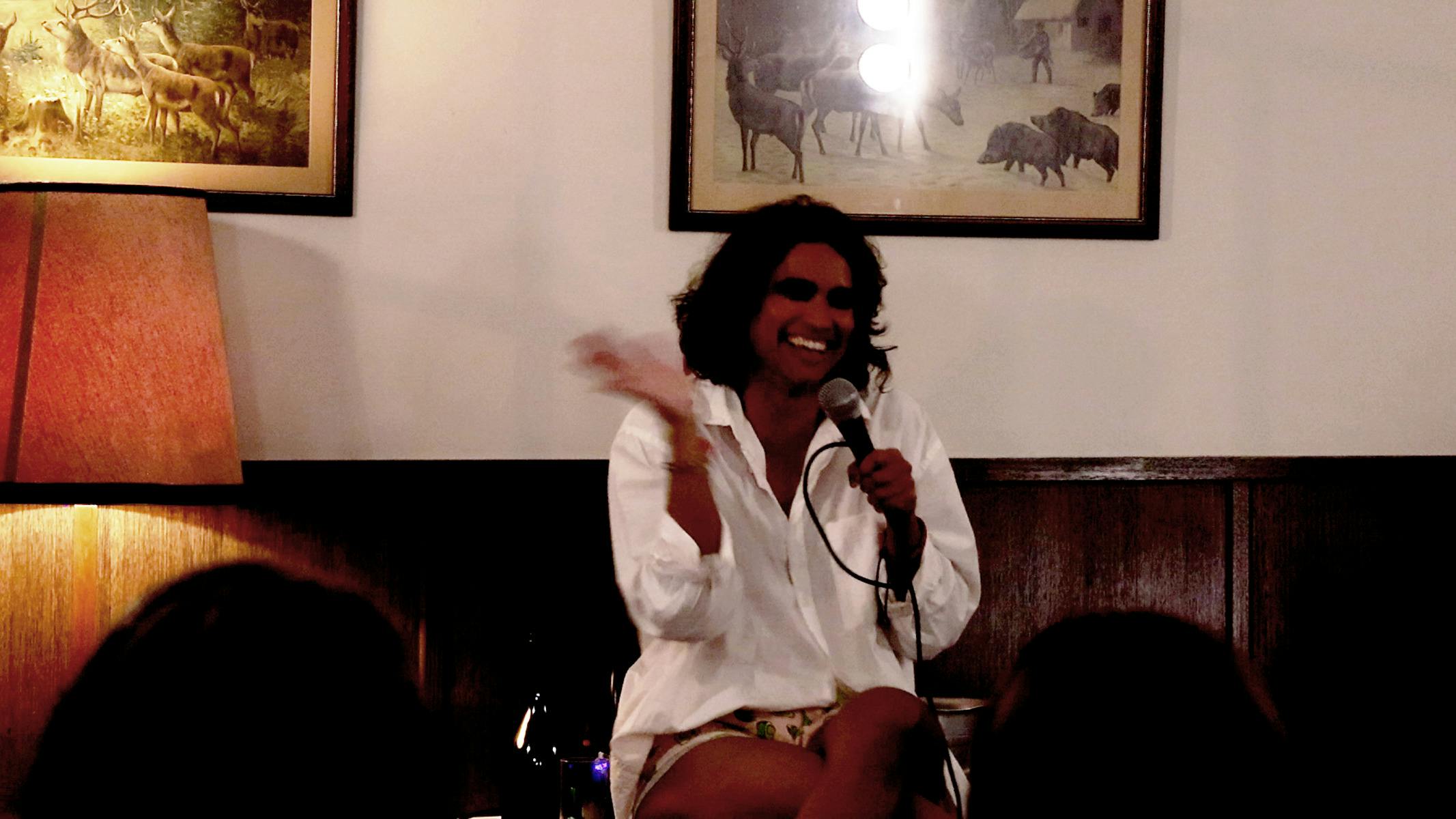 Neptune performing Sex Questions Welcome in Ballarat. Neptune sits on a chair holding a microphone