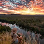 Girl watching the sunset from a hill over Nitmiluk National Park