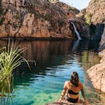 Woman looking at Maguk waterfall