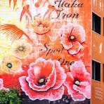 Corner of a building painted with poppies by artist, Mike Makatron