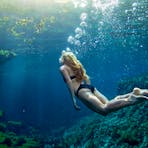 Woman swimming under the water in the Mataranka thermal pool