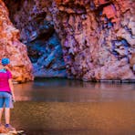 A woman with a bike helmet on looking at Redbank Gorge