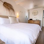 Ocean Room capturing bed, vanity, shower and toilet areas