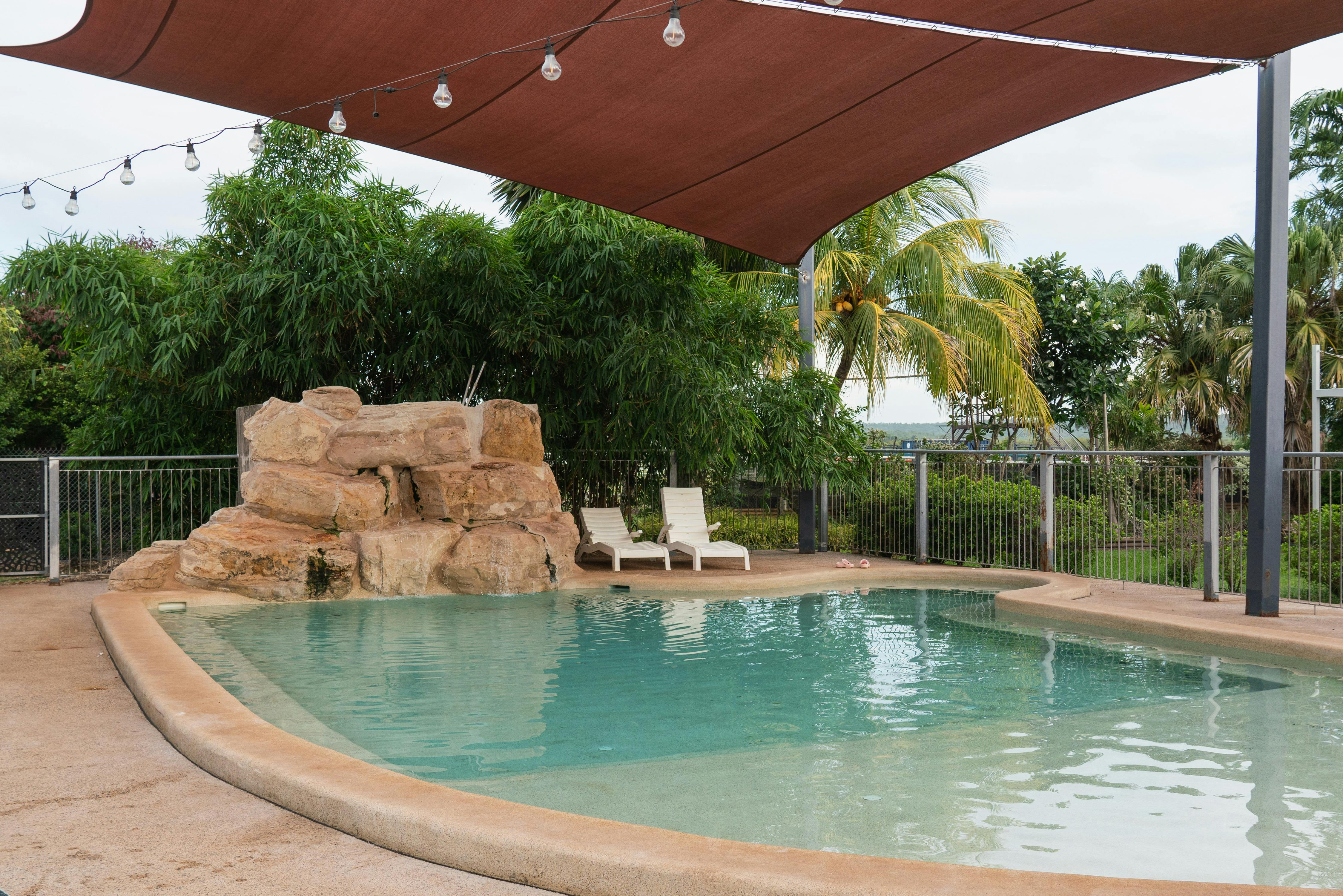 Outdoor swimming pool surrounded by tropical gardens at Darwin River Tavern
