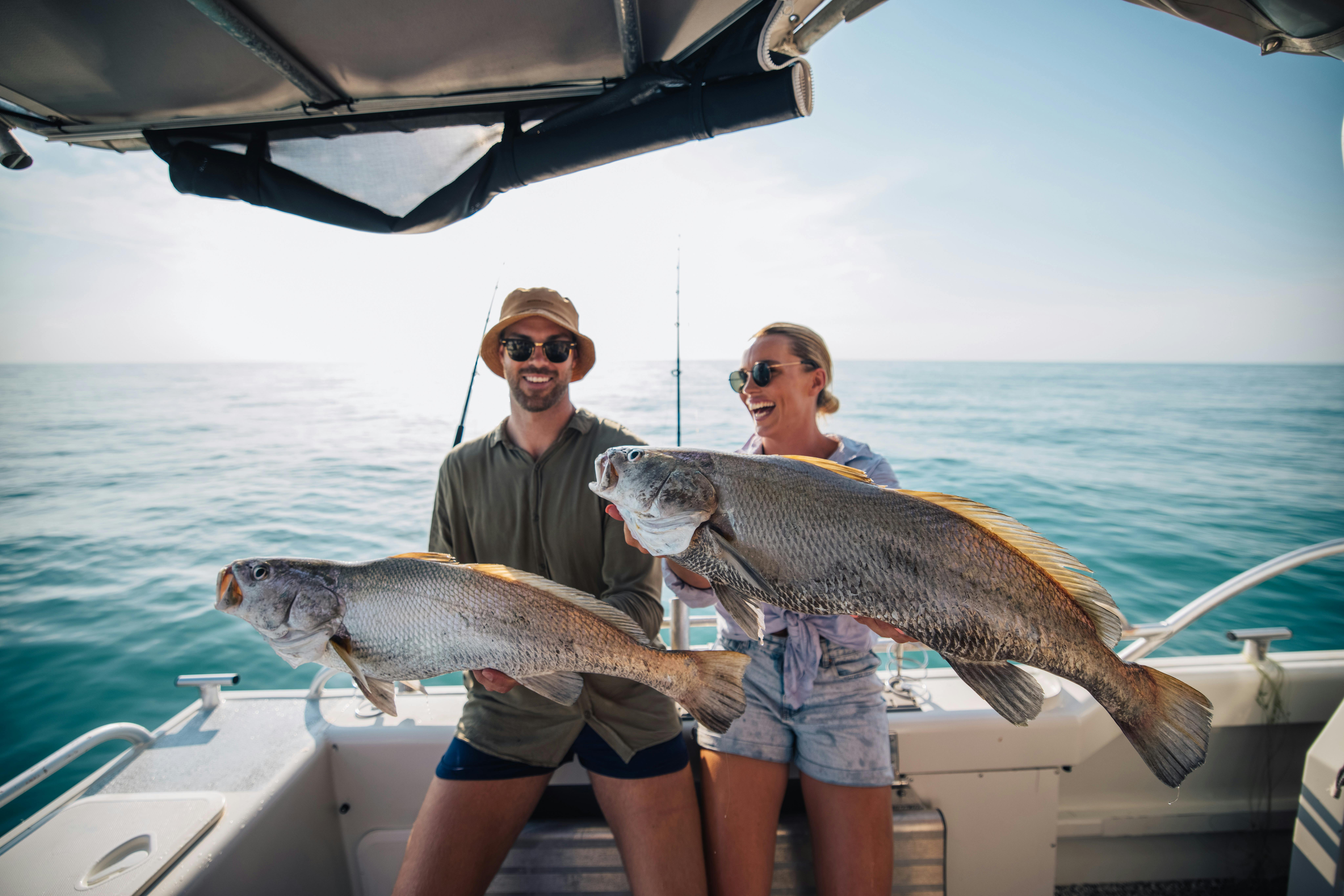 Backyard Bandits holding two jewfish on Cat 5 caught while Blue Water Fishing