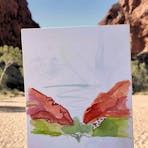 Watercolour painting held up in the landscape it was painted in