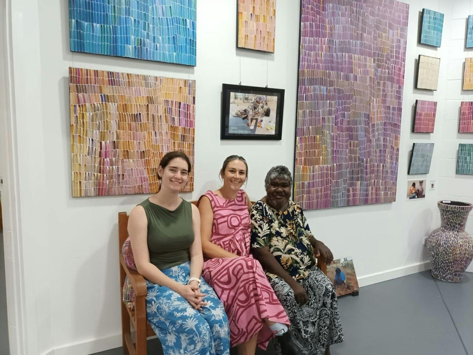 Staff member Eleanor Storey, Gallery Manager Simone Edney, with Jeannie Mills Pwerle