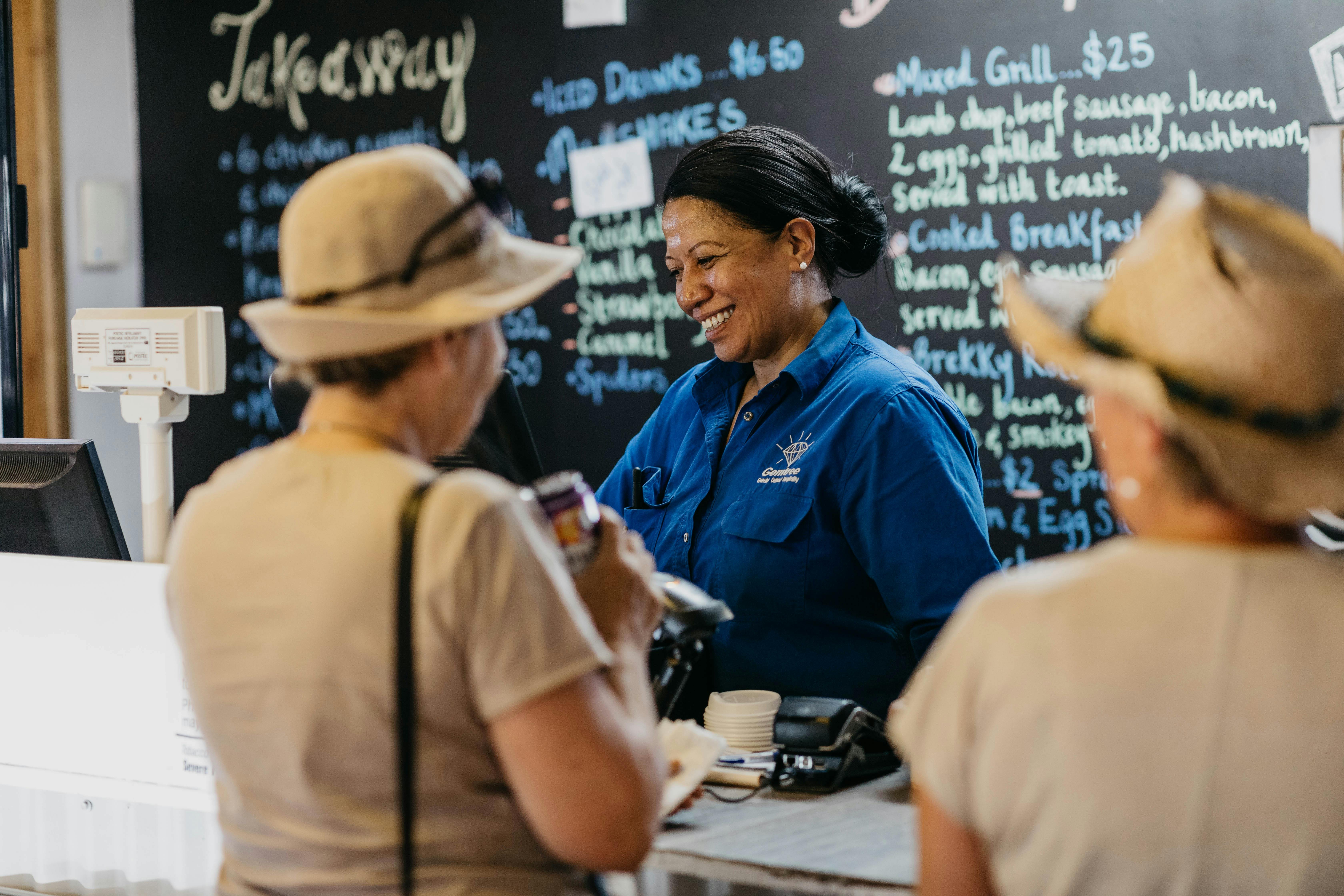 people ordering food from a blackboard menu