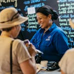 people ordering food from a blackboard menu