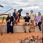 A guide demonstrating traditional Aboriginal wooden tools at the Earth Sanctuary