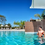 Couple relaxing in the waters of the Lagoon drinking a cocktail from the Swim Up Bar