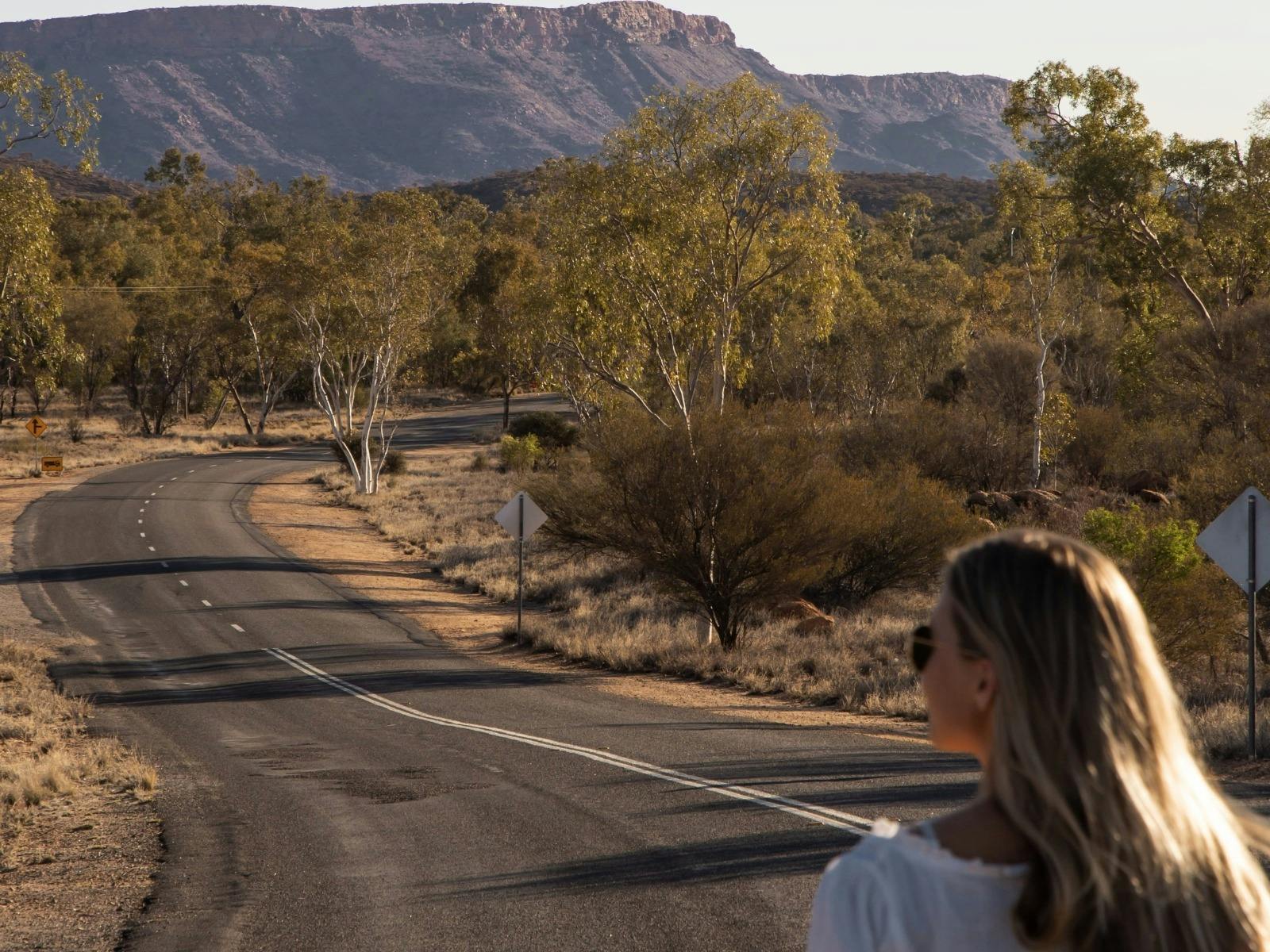 A young tourist enjoying the scenic natural views along an empty road