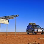 A four wheel drive near road signs on Bionns track in Simpson Desert