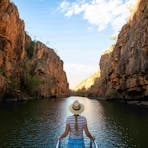Woman holding onto rails while touring on a cruise in Katherine Gorge